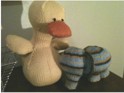 Photograph of knitted stuffed animals - a duck and an elephant.